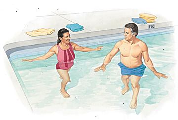 Mand og kvinde gå i lavvandede ende af swimmingpoolen.