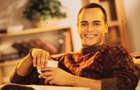 Billede af en ung mand smilende, holder en kop kaffe Billede af en ung mand smilende, holder en kop kaffe