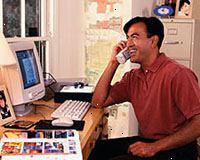 Billede af en mand, der arbejder på computeren, taler i telefon Billede af en mand, der arbejder på computeren, taler i telefon